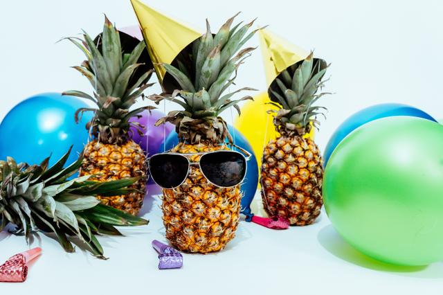 three party pineapples surrounded by balloons